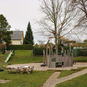 Großer Garten mit Spielgeräten, Kreativwerkstatt und separatem Fußballfeld.