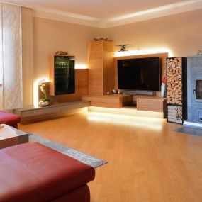 Wohnzimmer in Wildeiche geölt und Bronzemetall-Applikation, Kombination mit Schwarzglas