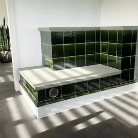 Wärme trifft Gemütlichkeit Ein Kachelofen mit integrierter Sitzbank ist mehr als nur ein Heizsystem – er ist ein Ort zum Verweilen.