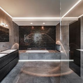Ein Blick in den Innenraum eines Badezimmers, gestaltet mit grauen und schwarzen Farbtönen.