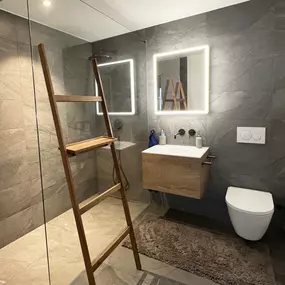 Ein Badezimmer mit Glaswand zur Dusche lässt selbst kleine Bäder großzügiger wirken.