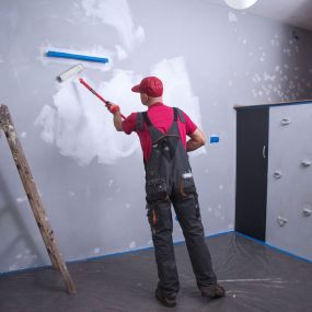 Maler, übermallt die Wand