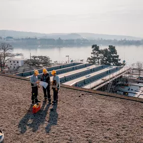 Elektroinstallateure studieren auf der Baustelle des Kongresshauses die Pläne für die Elektroinstallationen.