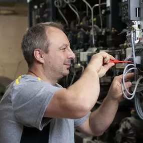 Unser Servicetechniker für Antriebstechnik, bei der Arbeit an einem Danfoss Frequenzumrichter.