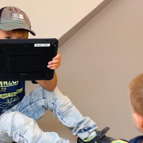 ein kind porträtiert ein anderes kind mit einem tablet-computer