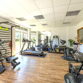 Das Bild zeigt den gerätegestützten Trainingsbereich mit Laufbändern und funktionellen Trainingsgeräten für Krankengymnastik am Gerät.