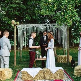 In einem dichten Wald stehen Braut und Bräutigam unter freiem Himmel und feiern ihre Trauung