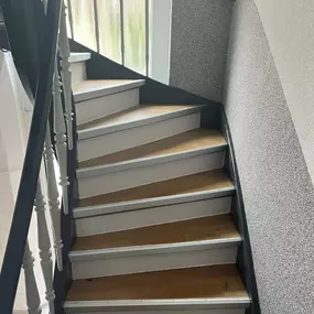 Das Bild zeigt eine fachgerecht mit Laminat belegte Treppe. Die Stufen wurden passgenau verkleidet, inklusive sauberer Kantenbearbeitung und farblich abgestimmter Leisten – für ein harmonisches Gesamtbild.