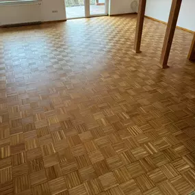 Das Bild zeigt ein aufgearbeitetes Eichen-Mosaikparkett mit geölter Oberfläche. Nach dem Schleifen kommt die natürliche Struktur des Holzes klar zur Geltung, das Öl verleiht dem Boden einen warmen, matten Farbton.