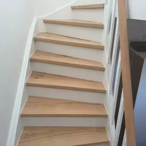 Das Bild zeigt eine aufgearbeitete Treppe aus echter Buche. Die Trittstufen, Setzstufen und Seitenwangen wurden fachgerecht geschliffen und anschließend gleichmäßig lackiert. Die Oberfläche wirkt nun wieder gepflegt, robust und modern.