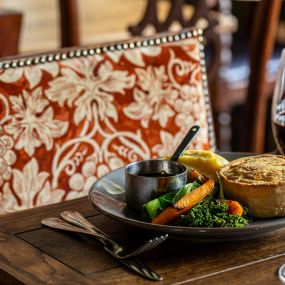 Handmade chicken & ham hock pie served with mash and buttered vegetables.