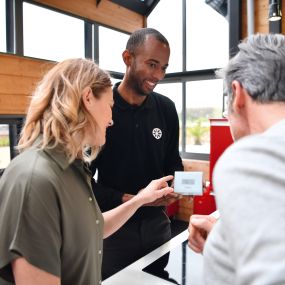 Technicien chauffagiste Garanka donnant des conseils sur le thermostat connecté à un client.