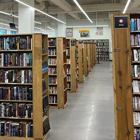 DVD section and shelves of books at HPB Westlane Avenue, a new and used bookstore that buys and sells items in Columbus, Ohio.