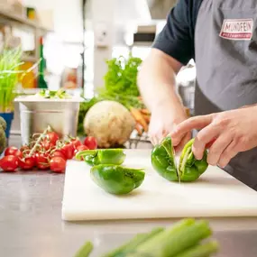 MUNDFEIN Mitarbeiter schneidet Paprika