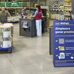 Lowe's customer checking out and pushing cart with insulation.