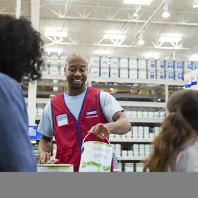 Close up of Lowe's blue bucket with paint sticks.
