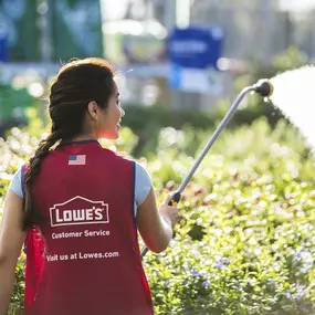 Photo of Lowe's employee watering plants in the Garden Center.
