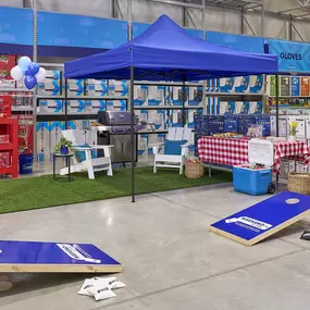In-store photo of Lowe's weekend event with games and outdoor products.