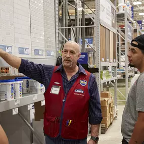 Lowe's team member assisting customers at DIY workshop.