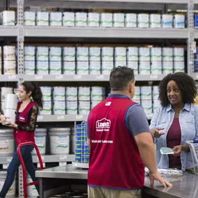 Lowe's team member assisting customer with paint samples.