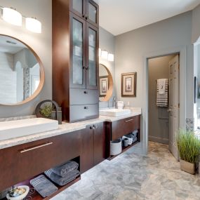 A contemporary take on the master bathroom with slab doors and warm woods.