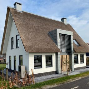 Nieuwbouw woonhuis, wit metselwerk met rietenkap. Traditioneel maar toch modern.