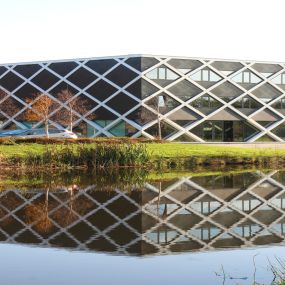 Nieuwbouw van een modern kantoor met veel glas en een uitdagende constructie.