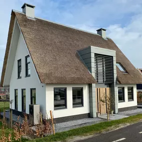Nieuwbouw woonhuis, wit metselwerk met rietenkap. Traditioneel maar toch modern.