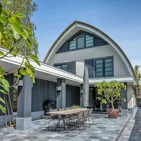 Nieuwbouw  villa in het landelijk gebied van Landsmeer. Een villa met een wit gestucte gevel en een rieten kap. Traditionele vormgeving in een modern jasje.