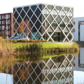 Nieuwbouw van een modern kantoor met veel glas en een uitdagende constructie.