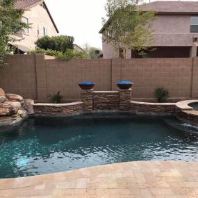 Rock ledge on one side of pool with fire bowls