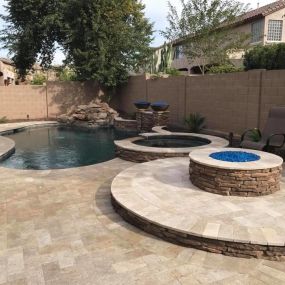 New construction freeform pool with spa spillover, firepit, and pavers