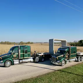 A convoy of three Morrell Transfer semitrucks is traveling down a country road.