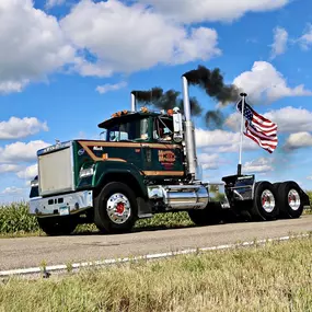 A classic green Mack Super-Liner semi-truck from Morrell Transfer is driving down a country road.