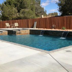 Geometric pool with rock ledge and water features