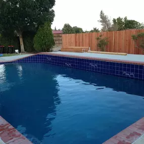 Inground pool with tile and uneven edge, higher wall on one side, very different and unique