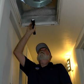 Inspecting air ducts for signs of mold.