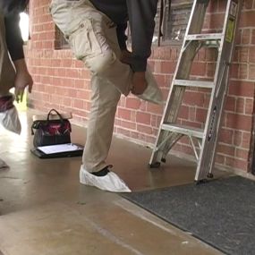 Technician putting on shoe covers to protect the client's home before we enter to clean the air ducts.