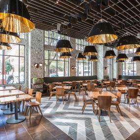The restaurant features an open kitchen which brings diners closer to the action to engage them with the food and the environment. The soft, rustic space, designed by Gensler, features a neutral, Italian aesthetic with a rough, sawn beam ceiling and custom wall covering.