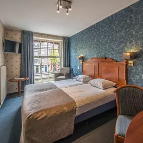 De Klassieke Kamer is een standaard tweepersoonskamer. De kamer op de foto is één van de kamers aan de voorkant van het hotel. Omdat wij 35 verschillende hotelkamers hebben, kan het zijn dat uw kamer andere details of kleuren heeft. Klassieke Kamers liggen op  verdiepingen in het hotel, zowel aan de voorkant, achterkant als aan de zijkant (Steegzijde).