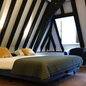 Deze Comfort Kamer ligt op de 3e etage (bovenste etage). Eén kamer ligt aan de voorzijde en één kamer ligt aan de achterzijde. De kamer heeft authentieke balken en een handgemaakt luik voor de ramen.