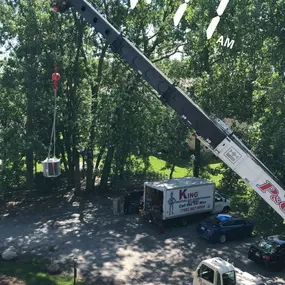 Crane lifting a new air conditioning system into place.