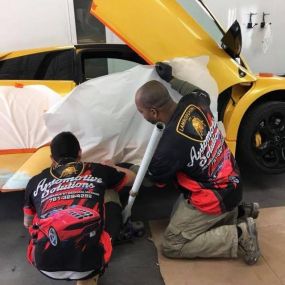 The guys are taping off a Lambo, its part of the paint prep procedure.