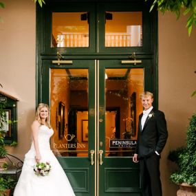 Bride and Groom take a photo on at the steps of a luxury hotel in Charleston, SC