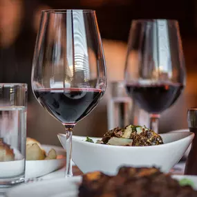 Wine glasses with red wine on table of food