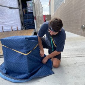 Aaron Movers employee wrapping delicate items in a protective blanket.