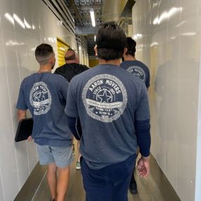 Aaron Movers walking down a storage facility hallway with the client