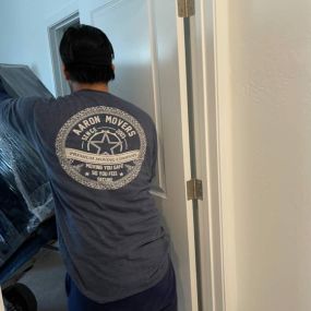 Aaron Movers employee moving large furniture into a new house.