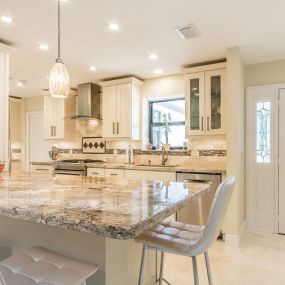 Modern kitchen with off-white cabinets and granite countertop.