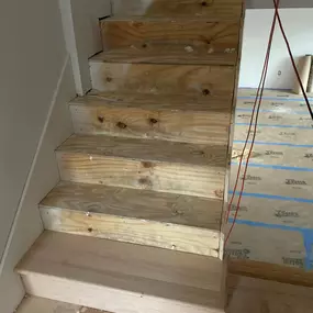 Installing new Red Oak treads and risers on a builder plywood stairs after the old carpet was removed.